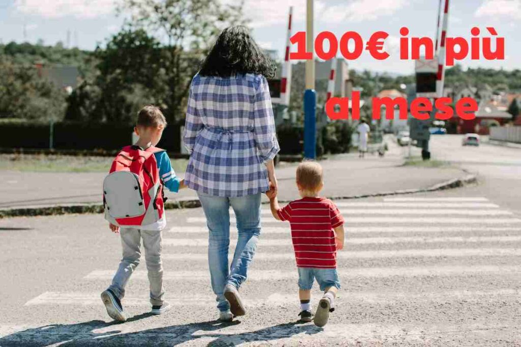 madre con due figli sulle strisce e scritta in rossa
