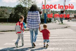 madre con due figli sulle strisce e scritta in rossa
