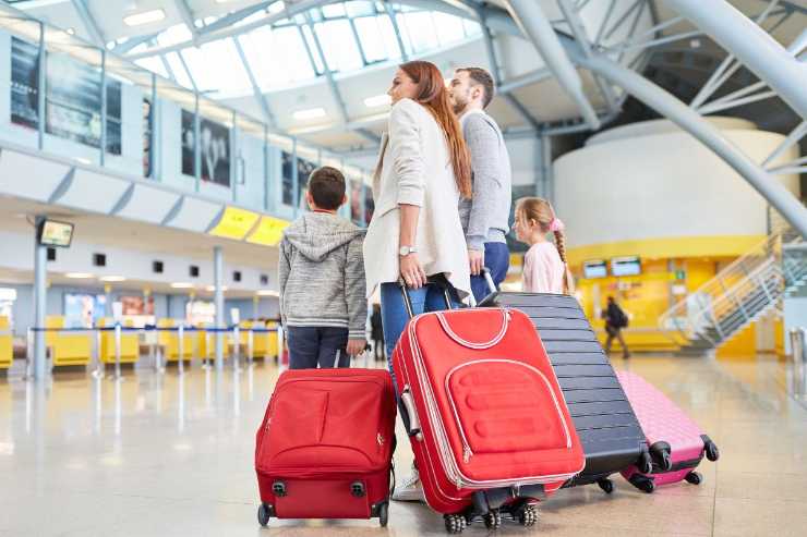 famigli in aeroporto con valige