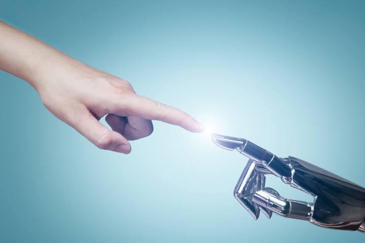 mano normale e robotica che si toccano